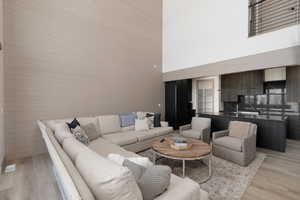 Living area featuring a high ceiling and light wood-style floors