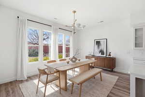 Dining area featuring light wood-type flooring and a chandelier