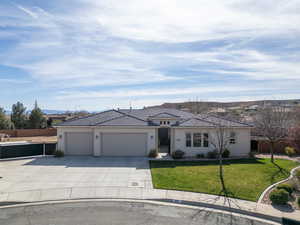 View of front of property with a garage, driveway, and stucco siding