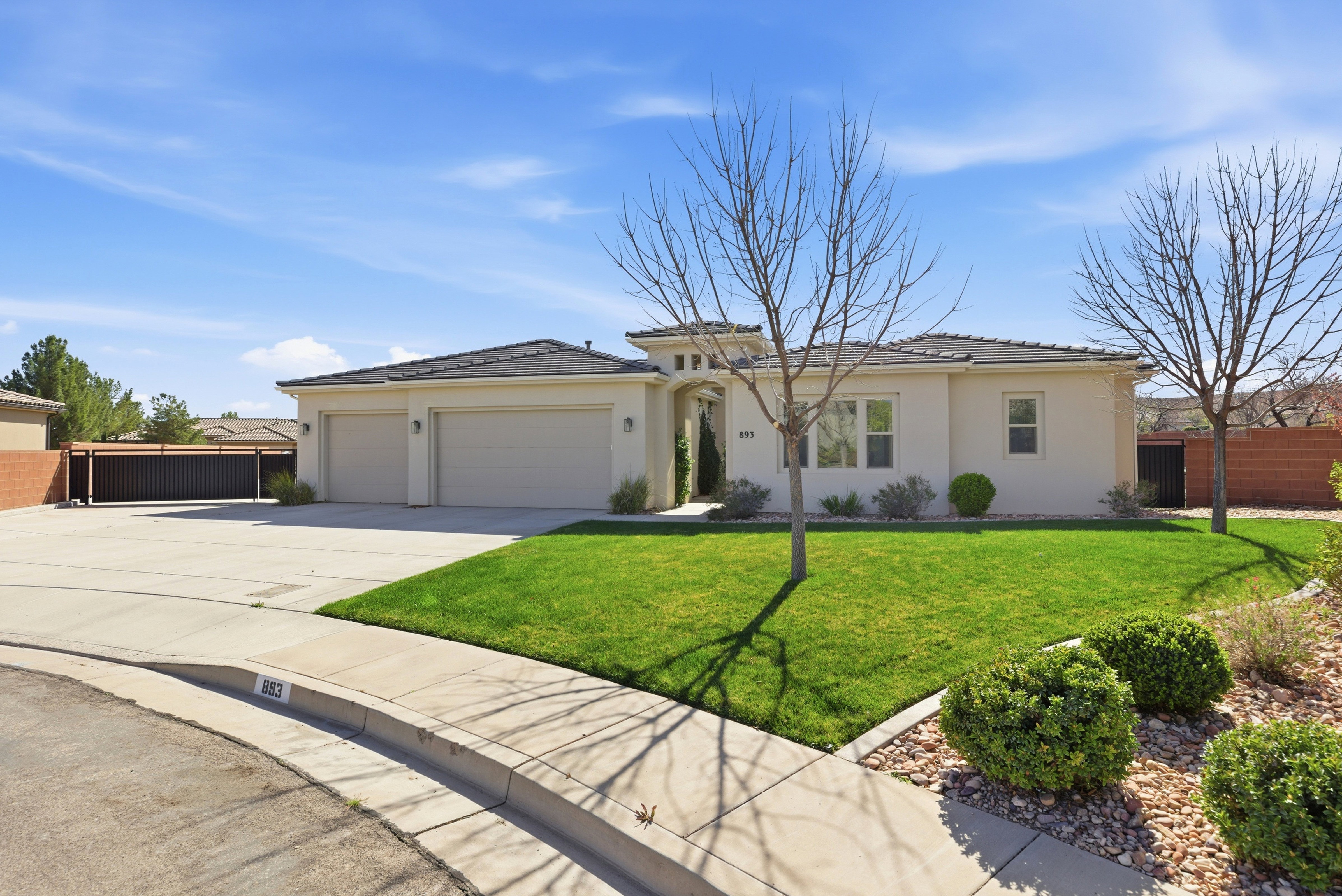 View of front facade with a garage, concrete driveway, stucco siding, and a tile roof
