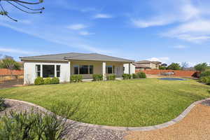 Rear view of house featuring stucco siding and a porch
