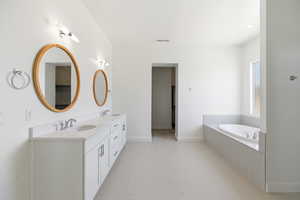 Full bathroom with double vanity and a bath