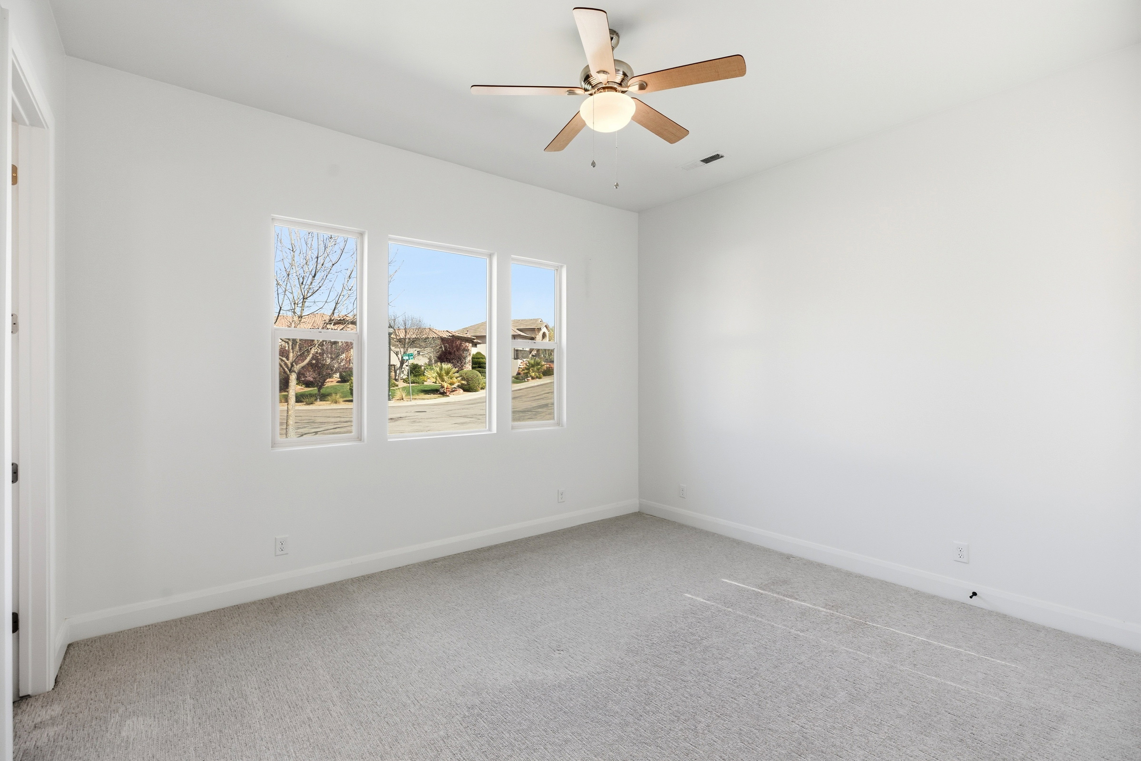 Spare room featuring light colored carpet and ceiling fan
