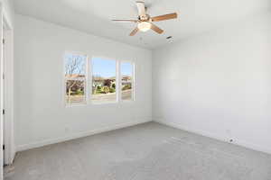Spare room featuring light colored carpet and ceiling fan