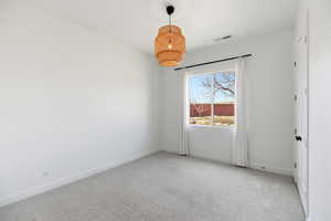 Spare room with light colored carpet and baseboards