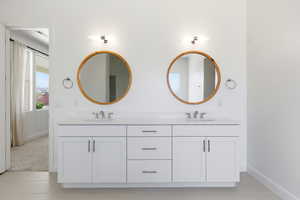 Bathroom featuring double vanity and baseboards