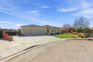View of front facade featuring a garage, concrete driveway, stucco siding, and a tile roof
