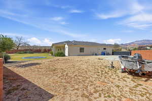 Rear view of property featuring a fenced backyard, a patio area, a mountain view, and stucco siding