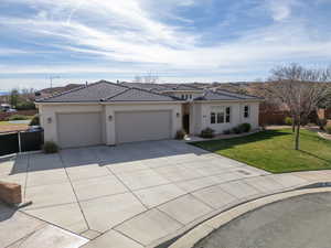 View of front of house with concrete driveway, stucco siding, a garage, and a tiled roof