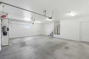 Garage featuring a central vacuum unit and gas water heater