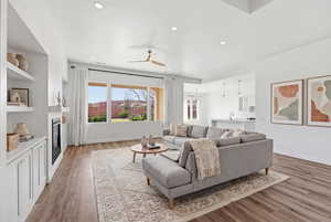 Living area featuring ceiling fan, light wood-style flooring, recessed lighting, and a fireplace