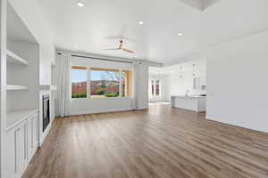 Unfurnished living room with ceiling fan, light wood-type flooring, recessed lighting, and a glass covered fireplace