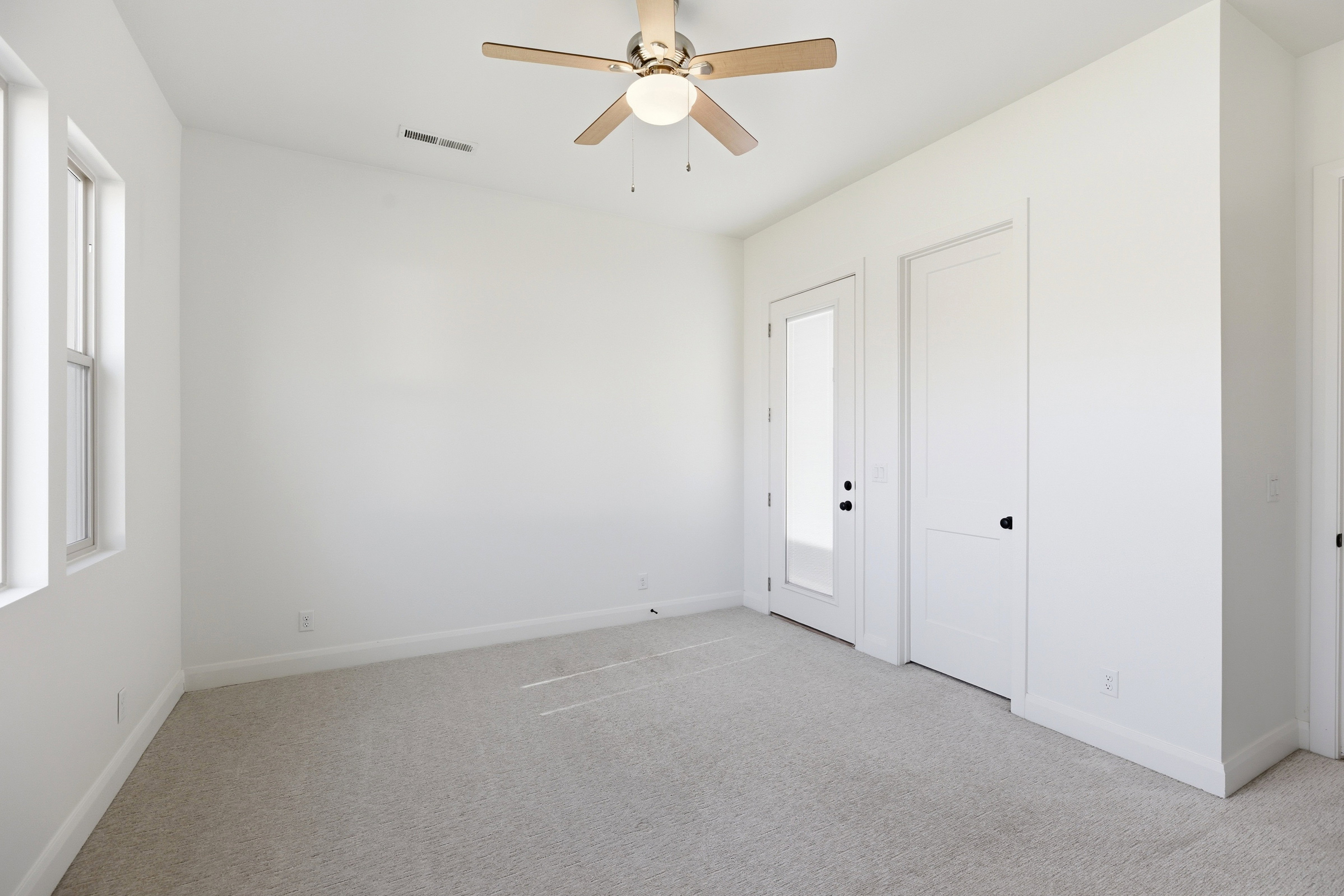 Unfurnished bedroom with light carpet and ceiling fan