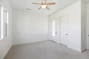 Unfurnished bedroom with light carpet and ceiling fan