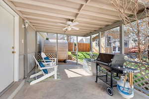 Sunroom with a ceiling fan and a patio