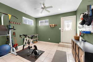 Workout room with ceiling fan, a textured ceiling, light tile patterned floors, and recessed lighting