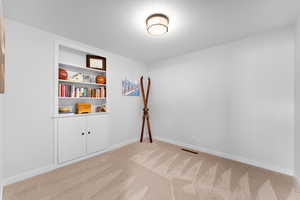 Unfurnished room with light carpet and a textured ceiling