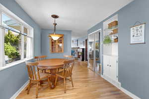 Dining space with light wood-type flooring and a fireplace