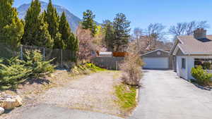 View of yard featuring a detached garage, a mountain view, and an outbuilding