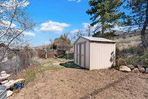 View of shed with a fenced backyard