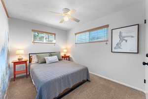 Bedroom featuring carpet flooring, ceiling fan, and a textured ceiling