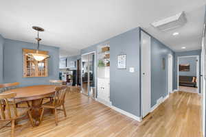 Dining room featuring light wood-type flooring and a fireplace