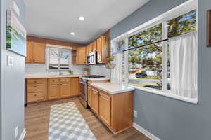 Kitchen featuring light countertops, stainless steel appliances, recessed lighting, decorative backsplash, and light wood-type flooring