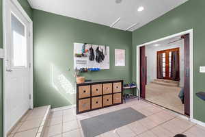 Entrance foyer with ceiling fan, light tile patterned flooring, a textured ceiling, healthy amount of natural light, and recessed lighting
