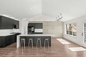 Kitchen with dark cabinets, modern cabinets, and a breakfast bar area