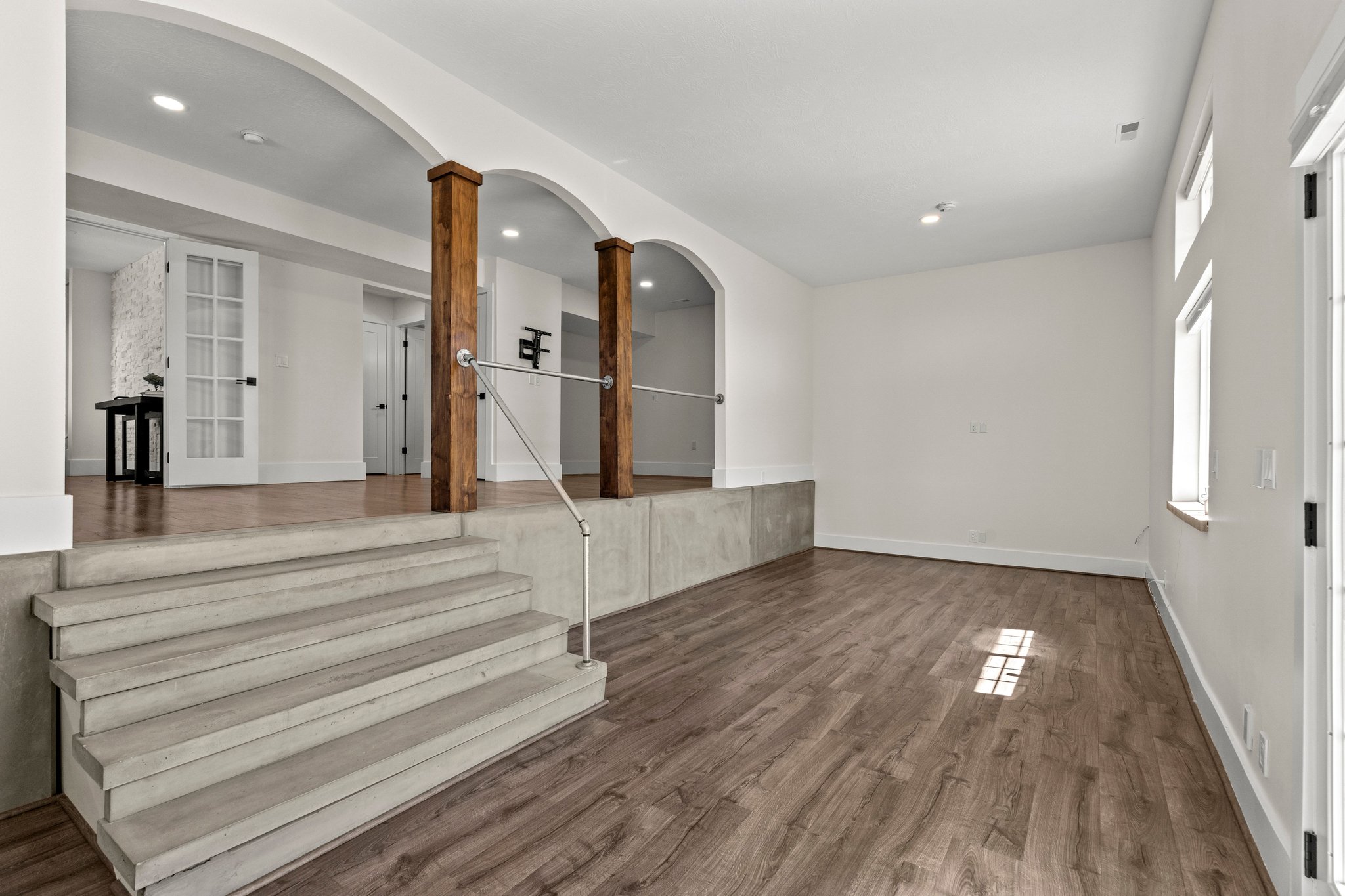 Entryway featuring arched walkways, dark wood-style flooring, and ornate columns