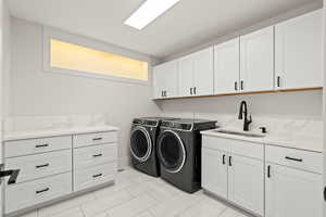 Laundry room featuring separate washer and dryer and cabinet space