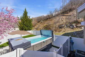 Wooden deck featuring a fenced backyard and a hot tub