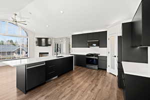 Kitchen with dark cabinets, a kitchen island with sink, modern cabinets, and recessed lighting