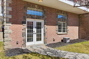 View of exterior entry with brick siding and french doors