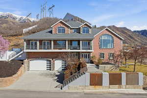 View of front of property with concrete driveway, a mountain view, an attached garage, and covered porch