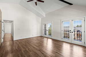 Unfurnished room featuring french doors, ceiling fan, lofted ceiling, and dark wood-type flooring