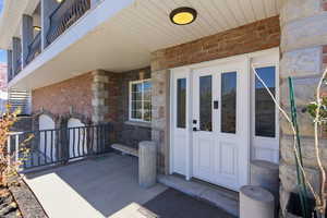 Entrance to property featuring stone siding and brick siding