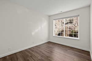 Unfurnished room with baseboards and dark wood finished floors