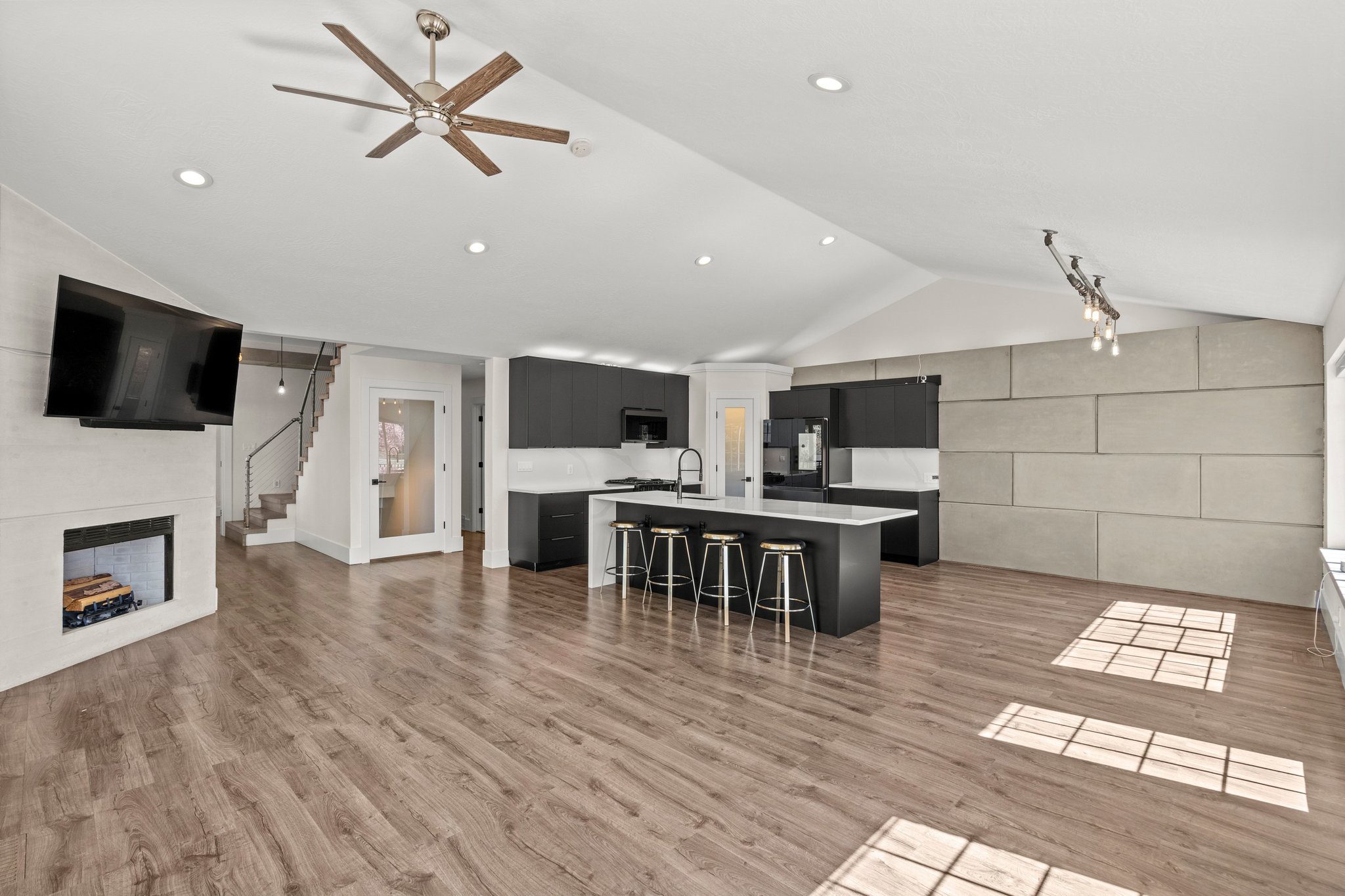 Kitchen with dark cabinetry, an island with sink, a breakfast bar, a ceiling fan, and open floor plan