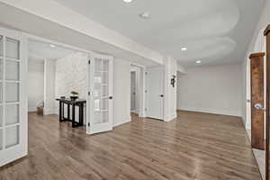 Unfurnished room with wood finished floors, recessed lighting, and french doors