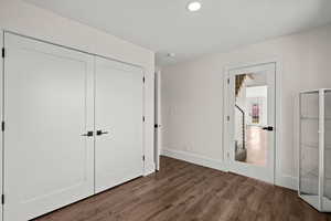 Unfurnished bedroom with a closet and dark wood finished floors
