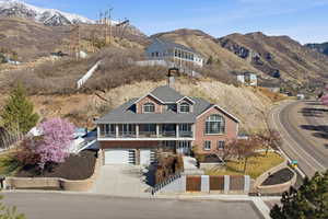 View of front of property featuring a balcony, a mountain view, a garage, and driveway