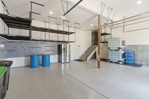 Garage featuring stainless steel fridge and a garage door opener
