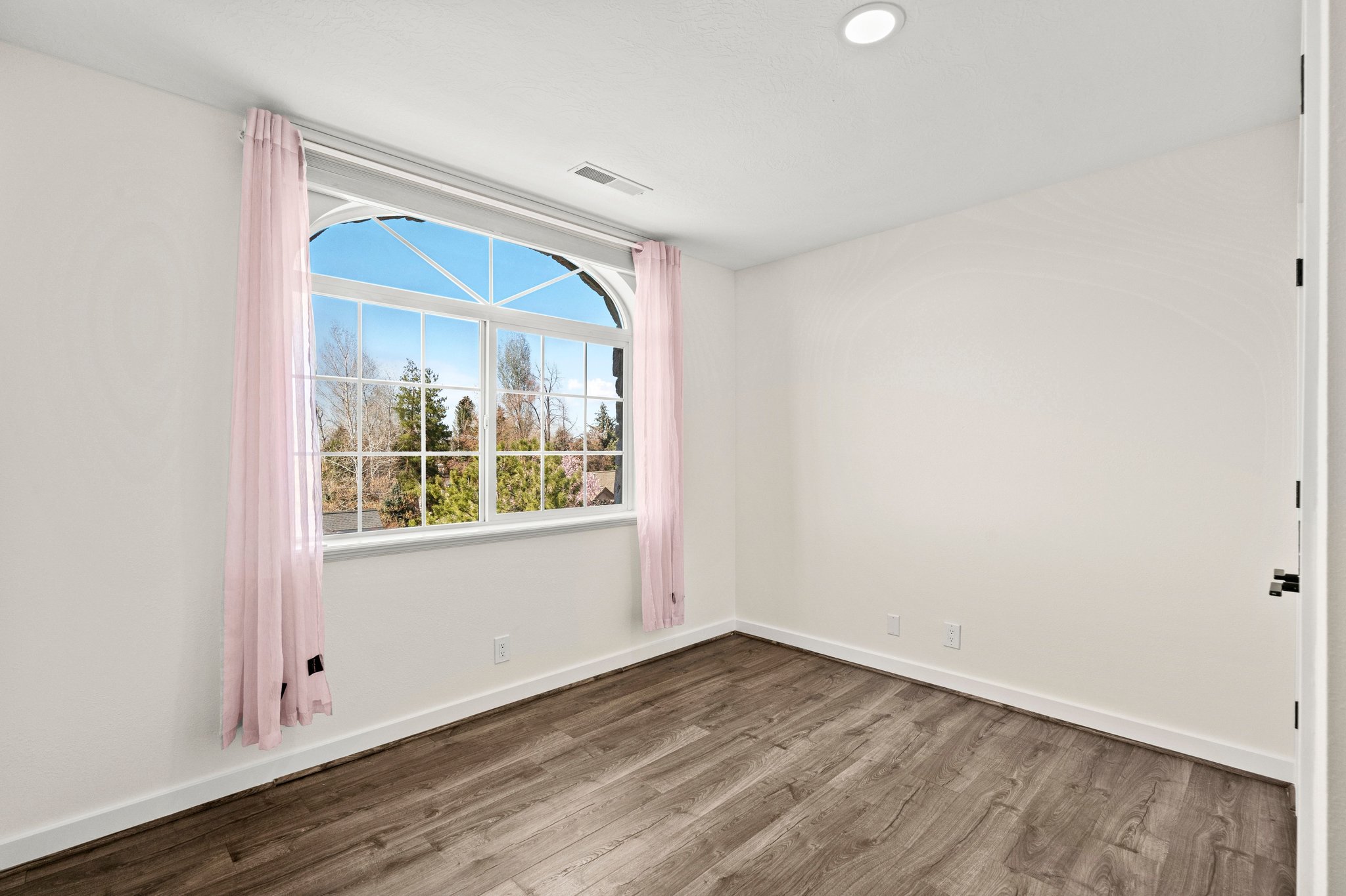 Empty room with dark wood-style floors and baseboards
