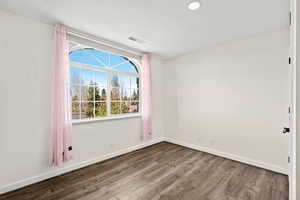 Empty room with dark wood-style floors and baseboards