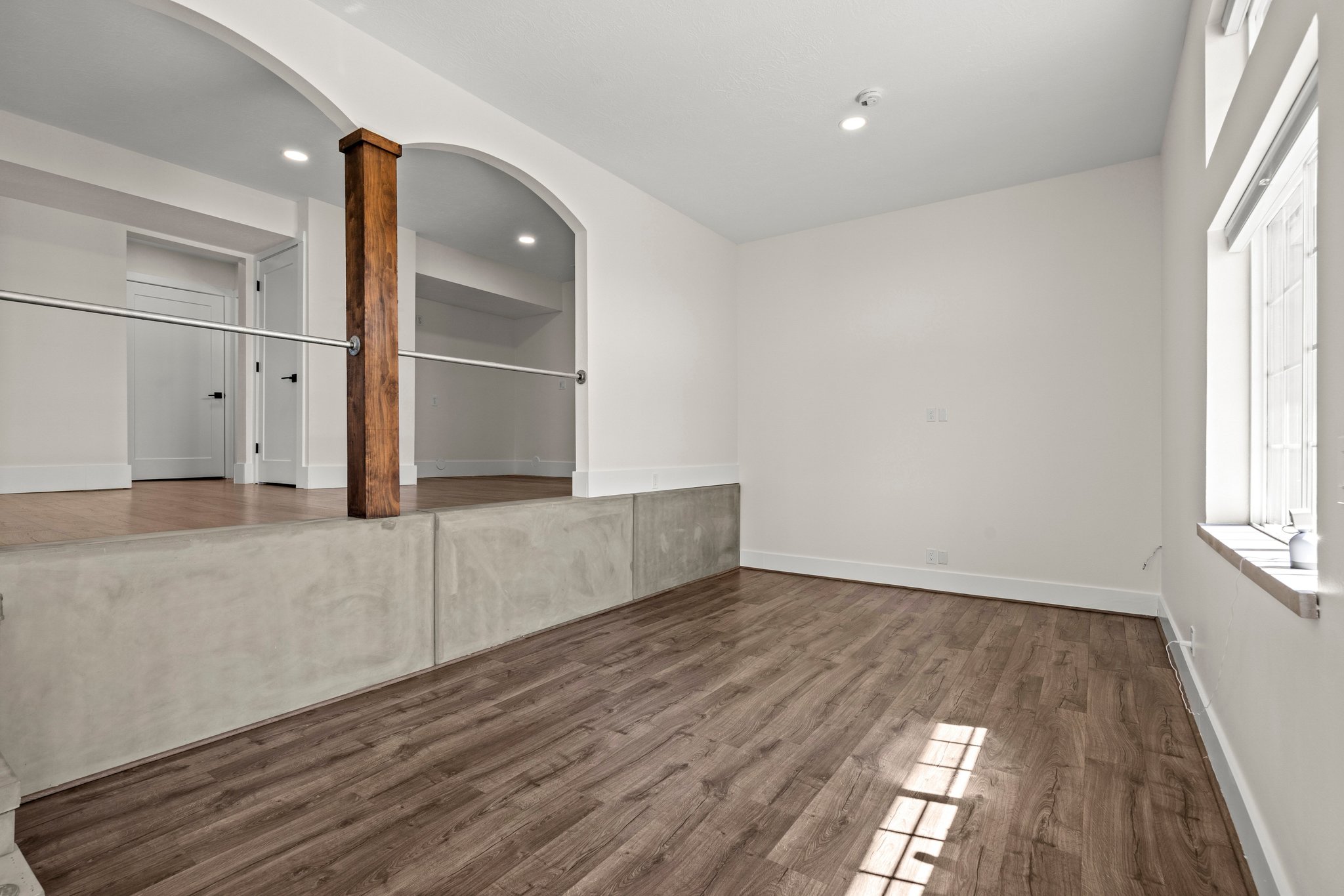 Unfurnished dining area featuring arched walkways, dark wood-type flooring, and decorative columns