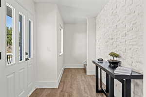 Foyer entrance with light wood-type flooring and an accent wall