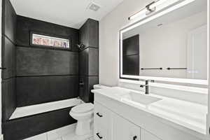 Full bath featuring vanity, shower / washtub combination, and light tile patterned floors