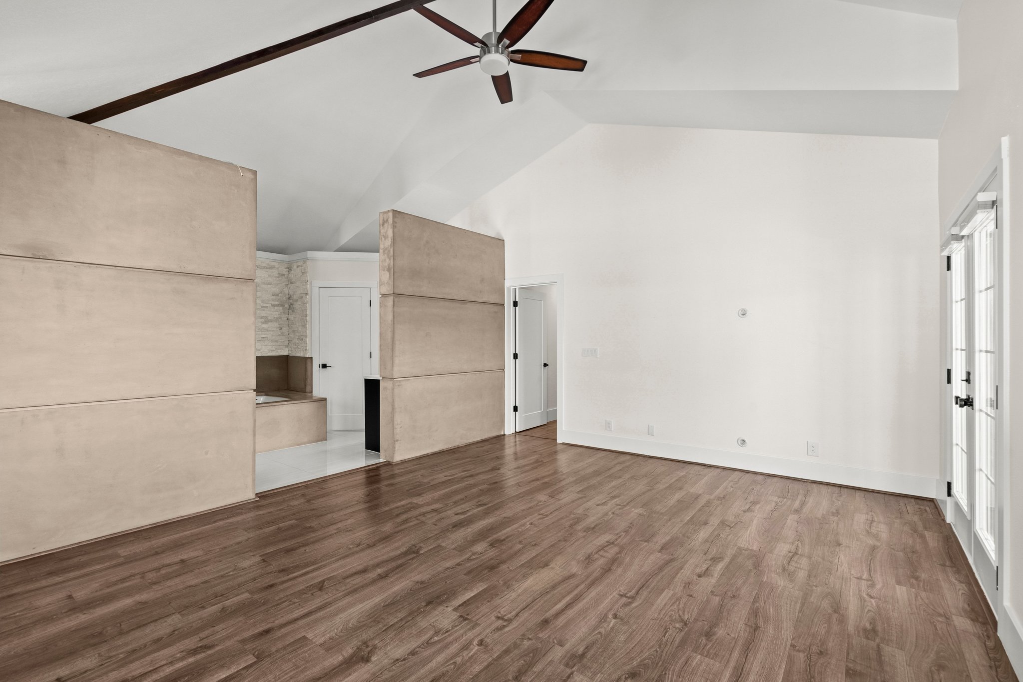 Unfurnished living room with vaulted ceiling, wood finished floors, and a ceiling fan