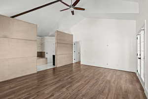 Unfurnished living room with vaulted ceiling, wood finished floors, and a ceiling fan